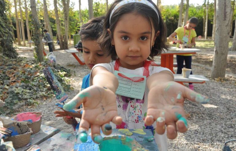 با چند ابزار ساده مانند، یک قطره رنگ، یک مشت خمیر و دستان کوچک پر از شور و هیجان می توانید دنیای کودکتان را پر از کشف و خلاقیت کنید. هر بازی و هر تجربه عملی، نه فقط سرگرمی، بلکه پلی برای رشد ذهن، مهارت‌های حرکتی و اعتمادبه‌نفس کودکتان است.  به گزارش ایرنا زندگی- فعالیت‌های هنری، به ‌ویژه بازی‌های حسی که به نام هنرهای کثیف شناخته می شود، یکی از مؤثرترین ابزارهای پرورش مهارت‌های شناختی، عصبی و اجتماعی در کودکان محسوب می‌شوند. طبق تحقیقات منتشر شده در سایت Artful Parent، این فعالیت‌ها با تحریک همزمان حواس پنجگانه، موجب رشد هماهنگی دست و چشم، بهبود تمرکز، افزایش انعطاف ذهنی و تقویت مهارت‌های حل مسئله در کودکان شده و نقش مهمی در آمادگی آن‌ها برای آینده دارند.  هنرهای کودکانه چیزی فراتر از سرگرمی  فعالیت‌های هنری کودکانه تنها سرگرمی نیستند بلکه نوعی سرمایه‌گذاری بر آینده ذهنی و شخصیتی کودکان به شمار می‌آیند. هر بار که کودک دست‌هایش را در رنگ فرو می‌برد یا خمیر را ورز می‌دهد، در حال ایجاد ارتباطات عصبی جدید و تقویت مهارت‌های شناختی خود است. پژوهشگران خارجی بر این باورند که تجربه عملی و خلاقیت در کودکان، پایه‌ای برای رشد تفکر مستقل و اعتمادبه‌نفس آنان است.  این فعالیت‌ها می‌توانند شامل نقاشی، ساخت اشکال سه‌بعدی با خمیر، یا ایجاد طرح‌های رنگی و ترکیبی باشند. هر کدام از این تجربه‌ها به کودک امکان می‌دهد تا با آزمایش، کشف و تکرار، مهارت‌های تازه‌ای کسب کند و با مشکلات کوچک روبه‌رو شده و راه حل‌های خلاقانه پیدا کند.  بیشتر بخوانید فرزندان ما بدون مهارت‌آموزی آسیب می‌بینند پرورش کودک شاد و مسئول با قدرت بازی و خلاقیت خانگی از پازل تا رباتیک؛ معرفی بازی‌هایی که مغز کودکتان را فعال می‌کند ایده‌های سرگرم‌کننده برای کودکان در قطعی برق چگونه خلاقیت کودک را پرورش دهیم  هنرهای حسی یا آزمایشگاه خلاقیت  نقاشی با نمک، بازی با خمیر، مرمرسازی با کرم اصلاح یا نقاشی با فوت از طریق نی، نمونه‌هایی از هنرهای حسی هستند. این فعالیت‌ها با تحریک حواس متعدد، هماهنگی دست و چشم، تمرکز و مهارت‌های حرکتی ظریف را تقویت می‌کنند. مثلاً در تکنیک مرمرسازی با کرم اصلاح، کودک با مشاهده حرکت رنگ‌ها و ترکیب آن‌ها با هم، به درک اولیه اصول فیزیک و ترکیب مواد می‌رسد.  بازی با خمیر نیز فرصت تجربه فضایی و سه‌بعدی فراهم می‌آورد و مهارت حل مسئله و تخیل کودک را پرورش می‌دهد علاوه بر این فعالیت‌هایی مانند هنر نقطه‌گذاری یا چاپ با گوش‌پاک‌کن، علاوه بر جنبه سرگرمی، باعث تقویت دقت و صبر کودک می‌شوند.  آزادی عمل و اعتماد به نفس  یکی از ویژگی‌های مهم هنرهای کثیف، کاهش ترس از اشتباه است. کودکان می‌آموزند که نتیجه تنها بخشی از فرایند است و ارزش واقعی در تجربه و خلق ایده‌های نو نهفته است. این آزادی عمل، روحیه جسارت و نوآوری را تقویت کرده و کودک را برای مواجهه با چالش‌های زندگی آماده می‌کند.  به گفته کارشناسان، کودکانی که فرصت ابراز خلاقیت بدون محدودیت دارند، نسبت به کودکانی که تنها نتیجه را می‌بینند، اعتمادبه‌نفس بالاتر و مهارت حل مسئله بهتری دارند. هنرهای پرآشوب به آن‌ها می‌آموزد که آزمون و خطا بخشی از یادگیری است و هیچ اشتباهی واقعاً شکست محسوب نمی‌شود.  چگونه خلاقیت کودک را پرورش دهیم  تقویت مهارت‌های اجتماعی و ارتباطی  فعالیت‌های گروهی هنری علاوه بر سرگرمی، مهارت‌های اجتماعی کودک را پرورش می‌دهند. یادگیری نوبت گرفتن، همکاری با دیگران، بیان نظر و پذیرش اشتباه، همگی بخشی از این تجربه هستند. همچنین لحظات مشترک والد و کودک هنگام خلق آثار هنری، به تقویت پیوند عاطفی و احساس امنیت روانی کودک کمک می‌کند.  بر اساس تحقیقات، کودکانی که به طور منظم در فعالیت‌های خلاقانه گروهی شرکت می‌کنند، توانایی بیشتری در برقراری ارتباط و حل تعارض‌ها دارند و مهارت‌های عاطفی و اجتماعی آن‌ها تقویت می‌شود.  پیشنهاد فعالیت‌های عملی در خانه  والدین می‌توانند با وسایل ساده و در دسترس، محیطی خلاقانه فراهم کنند. برخی از فعالیت‌های محبوب عبارتند از:  نقاشی با نمک برجسته: با چسب و نمک و رنگ، طرح‌های سه‌بعدی بسازید.  مرمرسازی با کرم اصلاح و رنگ خوراکی: تجربه‌ای بصری و سرگرم‌کننده که مهارت‌های حرکتی و هماهنگی چشم و دست را تقویت می‌کند.  نقاشی با فوت یا پاشیدن رنگ: تقویت هماهنگی دست و چشم و کنترل حرکتی.  ساخت آویز نوری با کاغذ شفاف: ترکیب نور و رنگ برای تحریک حس بینایی و خلاقیت فضایی.  بازی با خمیر یا گل طبیعی: تقویت انگشتان، تخیل و مهارت فضایی و سه‌بعدی.  نقاشی چرخشی و هنر تقارن: تجربه‌ای سرگرم‌کننده و هیجان‌انگیز که دقت و تمرکز کودک را بالا می‌برد.  این فعالیت‌ها می‌توانند با تغییر فصول و موضوعات مختلف جذاب‌تر شوند و کودک را به کشف محیط پیرامون تشویق کنند.  چگونه خلاقیت کودک را پرورش دهیم  مدیریت محیط و ایمنی  کلید موفقیت در این فعالیت‌ها، مدیریت محیط است. انتخاب زمان مناسب، استفاده از پیش‌بند و پوشش میز با روکش پلاستیکی، باعث کاهش نگرانی از کثیفی می‌شود. همچنین مشارکت کودک در تمیزکاری، مهارت مسئولیت‌پذیری را تقویت می‌کند.  برای خانواده‌هایی که نگران آشفتگی هستند، شروع با رنگ‌های کم‌آسیب و قابل شستشو، مانند فوم یا رنگ حمام، تجربه‌ای موفق و بدون استرس فراهم می‌کند. با گذشت زمان، می‌توان فعالیت‌های پیچیده‌تر و رنگارنگ‌تر معرفی کرد و سطح خلاقیت کودک را افزایش داد.