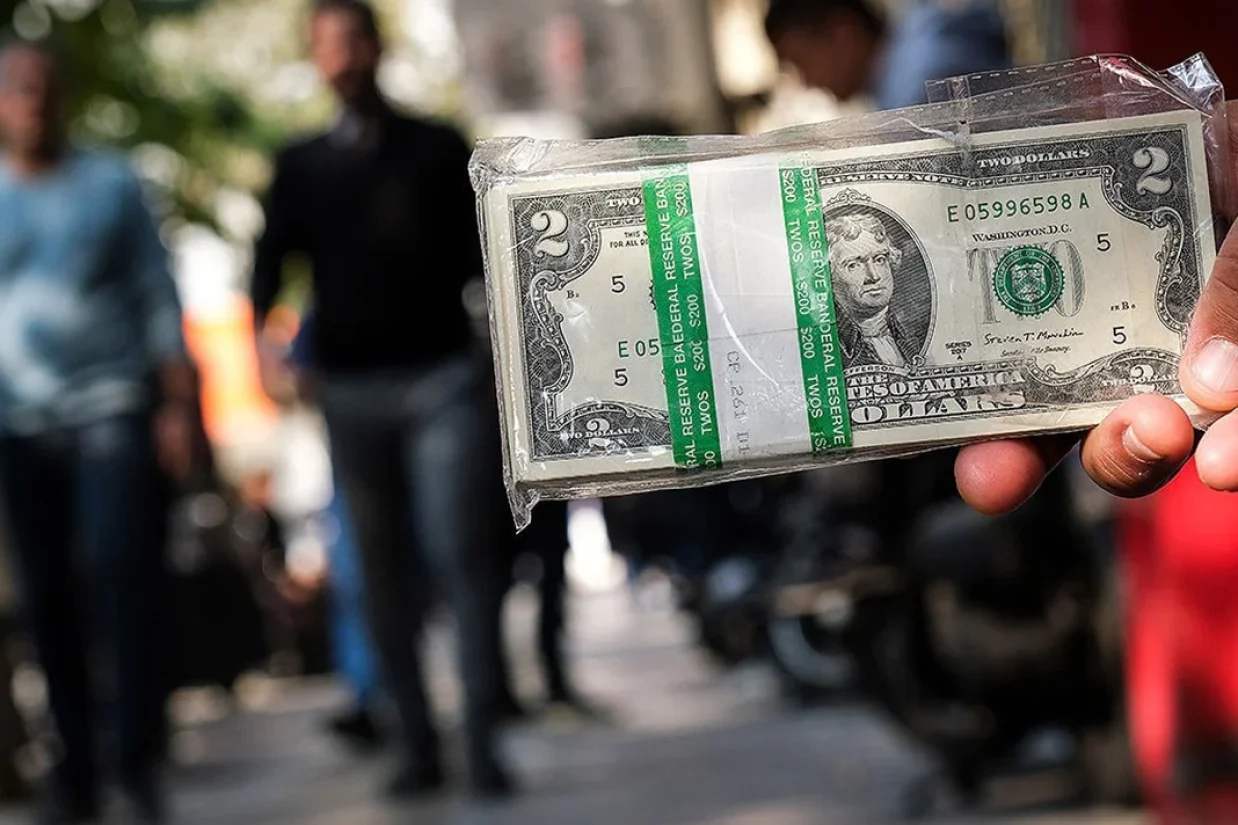 همزمان، دادستانی تهران دستور شناسایی و برخورد با عوامل اخلال در بازار، از معاملات میدانی تا فعالیت در فضای مجازی را صادر کرده است. با این اقدامات، نشانه‌هایی از احتیاط خریداران در بازار فردوسی دیده شده، اما آیا سیاست‌گذار می‌تواند از این فرصت برای بازگرداندن اعتماد استفاده کند، یا با تداوم نگرانی‌های تورمی و سیاسی، موج تقاضا دوباره برمی‌گردد؟  پیام تصمیم جدید مهم‌ترین اقدام اعلام‌شده بانک مرکزی، برنامه عرضه تا سقف دو میلیارد دلار اسکناس ارز است. طبق اطلاعیه منتشرشده، فروش مرحله اول، به ارزش یک میلیارد دلار، از طریق شعب منتخب بانک‌ها و صرافی‌های بانکی آغاز شده و افراد بالای ۱۸ سال می‌توانند با ارائه کارت ملی، تا سقف ۱۰ هزار دلار ارز دریافت کنند.در روزهایی که قیمت ارز با سرعت تغییر می‌کند، بخشی از تقاضای بازار نه از نیاز فوری به دلار، بلکه از ترس افزایش نرخ‌ها در آینده شکل می‌گیرد. خریدار برای آنکه از افزایش بعدی جا نماند، زودتر وارد بازار می‌شود و ورود خریداران بیشتر نیز می‌تواند همان افزایشی را رقم بزند که از آن می‌ترسند. در چنین وضعیتی، مدیریت بازار صرفاً به معنی تأمین اسکناس نیست. سیاست‌گذار باید بر انتظاری اثر بگذارد که خرید عجولانه را به رفتاری فراگیر تبدیل کرده است. پیام تصمیم جدید بانک مرکزی نیز روشن است. اگر تقاضا افزایش یابد، عرضه رسمی نیز حضور خواهد داشت. همین پیام ممکن است پیش از آنکه تمام ارز برنامه‌ریزی‌شده فروخته شود، بر رفتار معامله‌گران اثر بگذارد. کسی که احتمال می‌دهد در روزهای آینده هم امکان خرید ارز وجود داشته باشد، انگیزه کمتری برای خرید در اوج التهاب دارد. از طرف دیگر، فروشنده‌ای که انتظار افزایش پیاپی قیمت را از دست بدهد، ممکن است عرضه ارز خود را به تعویق نیندازد.عبدالناصر همتی، رئیس‌کل بانک مرکزی، همچنین گفته است از ابتدای سال ۱۸ میلیارد دلار ارز برای نیازهای معیشتی و تولید اختصاص یافته است. این رقم را نباید با برنامه تازه عرضه اسکناس یکی گرفت. ارز اختصاص‌یافته برای واردات و تولید، کارکرد و مسیر مصرف متفاوتی با دلاری دارد که برای پاسخ به تقاضا در بازار نقدی فروخته می‌شود.  بازار فردوسی چه نشانه‌ای داد؟ گزارش میدانی وبسایت «ایبنا» از محدوده فردوسی در ظهر هشتم مهرماه، تصویری آرام‌تر از روزهای پرتقاضا ثبت کرده است. صف خرید چشمگیری مقابل مراکز عرضه مشاهده نشده، شمار بیشتری از فروشندگان به چشم آمده‌اند. در آن ساعت، بخشی از فعالان بازار غیررسمی نیز بیشتر در موقعیت خرید بوده‌اند تا فروش.این تصویر برای تحلیل فضای روانی بازار مهم است. در بازار ملتهب، فقط نرخ روی تابلو تعیین‌کننده نیست و رفتار خریداران و فروشندگان نیز نشان می‌دهد کدام انتظار دست بالا را دارد. نبود هجوم برای خرید و افزایش احتیاط معامله‌گران می‌تواند به این معنا باشد که دست‌کم در آن مقطع، اطمینان به افزایش بی‌وقفه قیمت تضعیف شده است.نکته مهم‌تر، تغییر احتمالی در جهت تصمیم‌گیری است. اگر پیش‌تر ترس از افزایش نرخ، افراد را به خرید فوری سوق می‌داد، اکنون اعلام عرضه گسترده می‌تواند آنان را به مکث وادارد. این مکث، همان فرصتی است که بانک مرکزی برای کاستن از فشار روانی بازار به آن نیاز دارد. دستور قضایی چه چیزی را هدف گرفته است؟در کنار عرضه ارز، دادستانی تهران به ضابطان قضایی دستور داده عوامل اخلال در بازار ارز را، چه در میدان و چه در فضای مجازی، شناسایی و به مراجع قضایی معرفی کنند. بنا بر گزارش منتشرشده، اقدامات انجام‌شده در این زمینه باید روزانه به دادستانی گزارش شود.بازار ارز در دوره التهاب فقط در محل خریدوفروش شکل نمی‌گیرد. نرخ‌هایی که در کانال‌ها و صفحات مجازی منتشر می‌شوند، حتی اگر مبنای معاملاتی روشنی نداشته باشند، می‌توانند بر تصور مردم از مسیر آینده قیمت اثر بگذارند. وقتی یک عدد غیرمستند بارها بازنشر شود، ممکن است برای بخشی از مخاطبان به نشانه‌ای از «قیمت فردا» تبدیل شود و تقاضای احتیاطی را بالا ببرد. با این همه، باید میان اخلال و دستکاری بازار با تقاضای قانونی مردم برای ارز تفاوت گذاشت. خرید ارز برای سفر، تجارت یا حتی حفظ ارزش پس‌انداز، به‌خودی‌خود مصداق اخلال نیست. برخورد مؤثر زمانی است که بر رفتارهای مشخص و قابل اثبات، از جمله تقلب، قیمت‌سازی یا ایجاد شبکه سازمان‌یافته برای برهم‌زدن معاملات، متمرکز باشد. اگر مرز این رفتارها روشن نباشد، برخورد قضایی ممکن است فعالیت‌های قابل مشاهده را کاهش دهد، بی‌آنکه علت نگرانی خریداران را از میان ببرد. از همین رو، اقدام قضایی می‌تواند مکمل مدیریت بازار باشد، نه جایگزین آن. جلوگیری از انتشار اطلاعات گمراه‌کننده اهمیت دارد، اما حتی با حذف همه نرخ‌های جعلی نیز پرسش مردم درباره تورم، آینده درآمد ارزی کشور و ریسک‌های سیاسی پابرجا می‌ماند.  چرا پیام بانک مرکزی ممکن است اثر بگذارد؟ عبدالناصر همتی، رئیس‌کل بانک مرکزی، گفته است این بانک در برابر نوسان‌های غیرعادی بازار تماشاگر نخواهد بود و هر زمان نرخ‌ها از واقعیت‌های بنیادی اقتصاد فاصله بگیرند و نوسان‌های انتظاری تشدید شوند، مداخله خواهد کرد. او همچنین از اختصاص ۱۸ میلیارد دلار ارز از ابتدای سال برای نیازهای معیشتی و تولید خبر داده است؛ رقمی که البته کارکرد آن با برنامه تازه عرضه اسکناس به اشخاص حقیقی متفاوت است. اثر احتمالی این موضع‌گیری به اعتبار آن بستگی دارد. اعلام آمادگی برای عرضه ارز زمانی بر انتظارات اثر پایدارتر می‌گذارد که خریدار بتواند در عمل از مسیر رسمی ارز تهیه کند، شرایط فروش روشن باشد و بازار تصور نکند مداخله پس از چند روز متوقف خواهد شد. به بیان دیگر، آنچه آرامش ایجاد می‌کند تنها بزرگی عدد دو میلیارد دلار نیست؛ باورپذیری و استمرار اجرای برنامه نیز اهمیت دارد. این تفاوت در دوره‌های هیجان ارزی تعیین‌کننده است. اگر فعالان بازار تصور کنند عرضه صرفاً اقدامی کوتاه‌مدت برای پایین آوردن نرخ است، ممکن است خرید خود را چند روز به تأخیر بیندازند و سپس بازگردند. اما اگر احساس کنند بانک مرکزی برای پاسخ به نوسان‌های غیرعادی برنامه مشخص و قابل اجرا دارد، انگیزه شرط‌بندی بر افزایش سریع قیمت کمتر می‌شود. در عین حال، نباید از عرضه اسکناس انتظار بیش از ظرفیت آن داشت. بانک مرکزی می‌تواند بر سرعت تغییر قیمت و رفتار کوتاه‌مدت معامله‌گران اثر بگذارد، اما همه عواملی که مردم را نگران آینده نرخ ارز می‌کنند در اختیار این نهاد نیستند.  مداخله هدفمند یا تکرار تثبیت پرهزینه؟ مداخله بانک مرکزی در بازار ارز الزاماً به معنای هدر دادن ذخایر نیست. در بازاری که ترس از افزایش قیمت، خود به عامل افزایش تقاضا تبدیل شده، عرضه به‌موقع می‌تواند این چرخه را کند کند و به خریداران فرصت بدهد به‌جای تصمیم‌گیری در اوج هیجان، شرایط را دوباره ارزیابی کنند. پرسش این است که مداخله با چه هدفی، در چه حجمی و تا چه زمانی انجام می‌شود. اگر هدف، جلوگیری از جهش‌های کوتاه‌مدت و تأمین نیازهای واقعی باشد، عرضه ارز می‌تواند بخشی از یک برنامه مدیریت بازار باشد. اما اگر هدف به نگه‌داشتن نرخ در سطحی ثابت، مستقل از تورم و شرایط تجارت خارجی، تبدیل شود، هزینه سیاست بالا می‌رود. تجربه دوره‌هایی از اقتصاد ایران نشان داده است که آرامش نرخ ارز در ظاهر، بدون کنترل تورم و رشد نقدینگی، لزوماً پایدار نمی‌ماند و حتی ممکن است فشارهای انباشته‌شده را به آینده منتقل کند. برای قضاوت درباره برنامه کنونی، انتشار منظم اطلاعات ضروری است: چه میزان از یک میلیارد دلار مرحله اول فروخته شده؟ عرضه با چه سازوکاری ادامه می‌یابد؟ آیا دسترسی متقاضیان در عمل آسان بوده است؟ و مهم‌تر از همه، پس از فروکش‌کردن اثر خبر اولیه، بازار چگونه رفتار می‌کند؟ پاسخ این پرسش‌ها روشن می‌کند دو میلیارد دلار به ابزاری برای مدیریت نوسان تبدیل می‌شود یا تنها فرصتی کوتاه برای تنفس بازار فراهم می‌آورد.  آینده بازار؛ آرامش ممکن، ثبات مشروط در کوتاه‌مدت، آغاز فروش رسمی اسکناس و اعلام آمادگی برای عرضه بیشتر می‌تواند بخشی از فشار خرید را کم کند. بویژه اگر معامله‌گران احساس کنند بانک مرکزی برای پاسخ به تقاضا توان و برنامه مشخص دارد. برخورد با قیمت‌سازی و اطلاعات گمراه‌کننده نیز ممکن است از شدت نوسان‌های ناشی از شایعه بکاهد. با این حال، از مشاهدات یک روز بازار یا برآورد یک کارشناس نمی‌توان مسیر قطعی نرخ دلار در هفته‌های آینده را نتیجه گرفت. سناریوی محتاطانه‌تر این است که بازار پس از موج اولیه خبر عرضه، دوباره به عوامل تعیین‌کننده‌تر واکنش نشان دهد: تورم و رشد نقدینگی، وضعیت بودجه، درآمدهای ارزی، شرایط تجارت خارجی و تحولات سیاسی. اگر این عوامل به کاهش نگرانی‌ها کمک کنند، مداخله بانک مرکزی فرصت بیشتری برای اثرگذاری خواهد داشت. اگر فشار آنها ادامه پیدا کند، عرضه اسکناس احتمالاً بیشتر سرعت افزایش نرخ را کم می‌کند تا اینکه به‌تنهایی مسیر بلندمدت بازار را تغییر دهد.بانک مرکزی اکنون دو برنامه در پیش دارد. اول اجرای شفاف و مؤثر عرضه‌ای که تا سقف دو میلیارد دلار برای آن برنامه‌ریزی کرده است و دوم، پرهیز از این تصور که آرام‌شدن چندروزه معاملات، معادل حل مسأله ارز است. بازار ممکن است با عرضه بیشتر آرام بگیرد، اما ثبات ماندگار زمانی شکل می‌گیرد که ریسک‌های اقتصادی و سیاسی دلار نیز ضعیف‌تر شده باشد.
